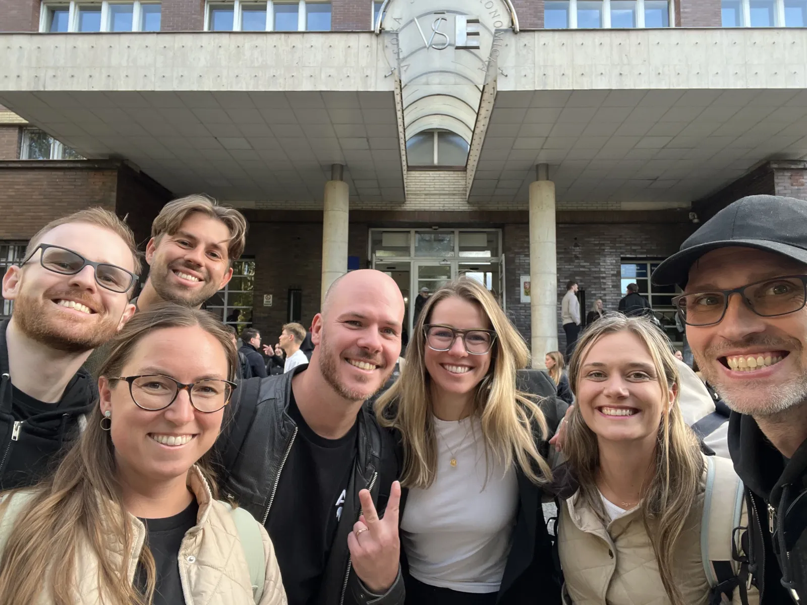 Members of the 4IT580 teaching team taking a selfie in front of the VŠE main building